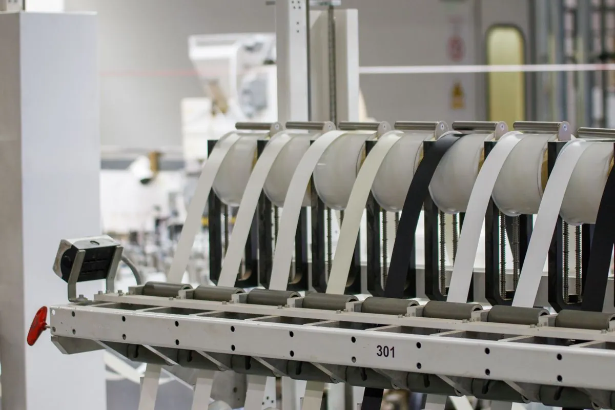 A production line with numbered stations and material feeding through rollers